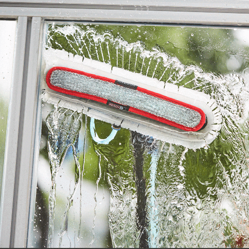 Reach-and-wash window cleaning pole reaching upper-floor windows from the ground